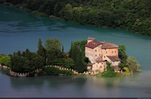 an island in the middle of a lake with a castle at Albergo Caffe Centrale in Mezzocorona