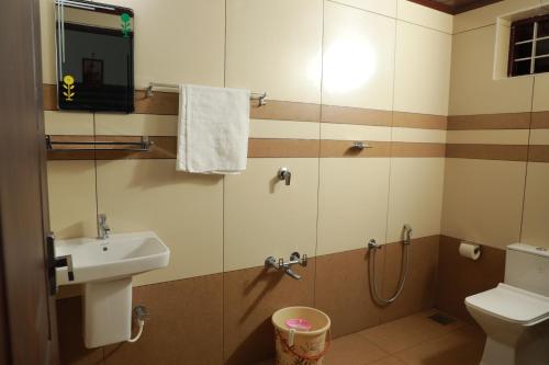 a small bathroom with a sink and a shower at Athirappilly Ambady Resort in Athirappilly