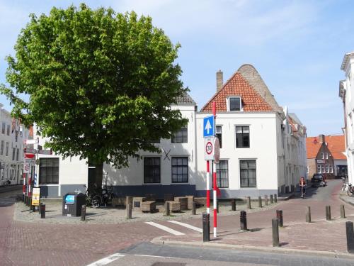 a street sign on a pole in front of a building at De Soeten Inval in Middelburg