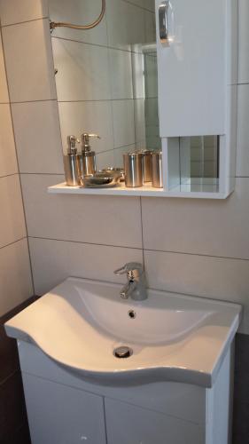 ein weißes Waschbecken mit einem Spiegel darüber in der Unterkunft Fanaraki Beach Studios in Mirina