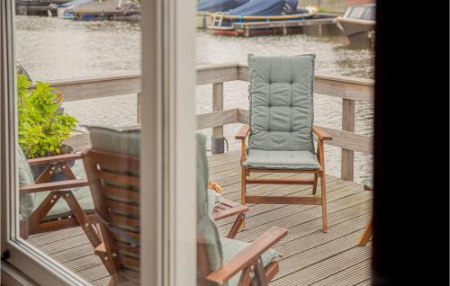 a chair sitting on a deck next to the water at Amazing home in Breukelen with 2 Bedrooms and WiFi in Breukelen