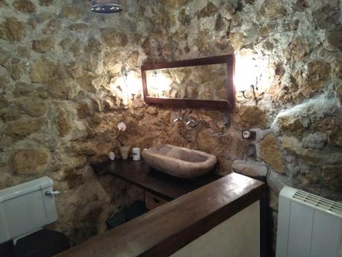 Baño de piedra con lavabo y espejo en A 11 km de Riopar Casa Acogedora con sabor antaño, 