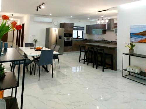 a kitchen and dining room with a table and chairs at Penthouse, Sea Views and Private Roof Top Pool in Il-Pergla