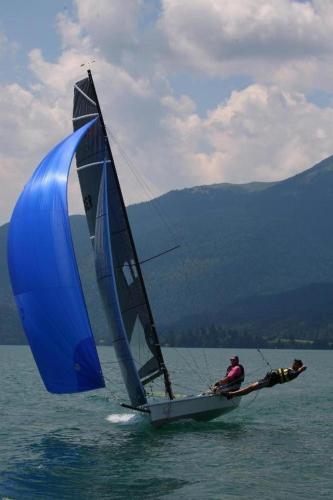 a man on a sail boat in the water at Ferienwohnung Heimbeck Kochel in Kochel