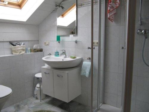 La salle de bains est pourvue d'un lavabo et d'une douche. dans l'établissement Ferienwohnung Heimbeck Kochel, à Kochel am See