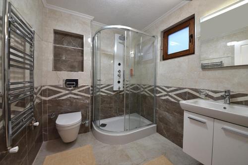 y baño con ducha, aseo y lavamanos. en Peaceful House in Bozcaada en Çanakkale