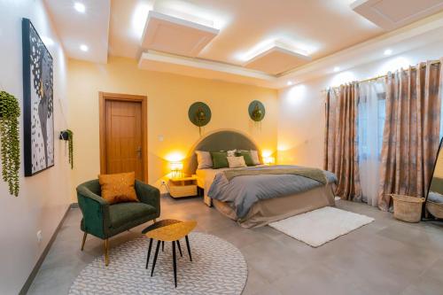 ein Schlafzimmer mit einem Bett und einem Stuhl in einem Zimmer in der Unterkunft Lighthouse Signature Suites in Dakar