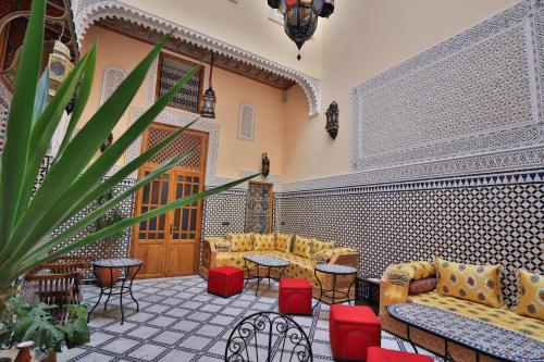 un hall avec des canapés, des tables et une plante en pot dans l'établissement Riad Diamant De Fes, à Fès