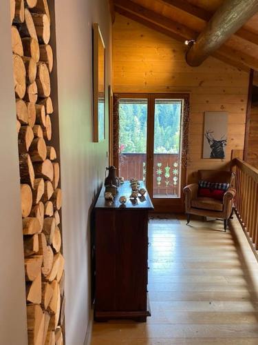 - un couloir d'une cabane en rondins avec une table et des chaises dans l'établissement Family Chalet, Stunning Views & New Hot Tub, à La Côte dʼArbroz