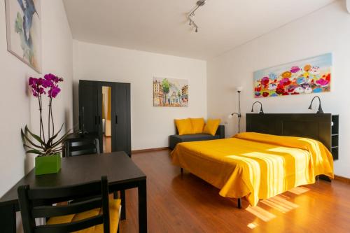 Un dormitorio con una cama amarilla y una mesa en Holiday rental St Peter's area, en Roma