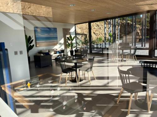 ein Esszimmer mit Tischen und Stühlen in einem Raum in der Unterkunft Hermoso Departamento Nuevo en el Corazón de Papudo in Papudo