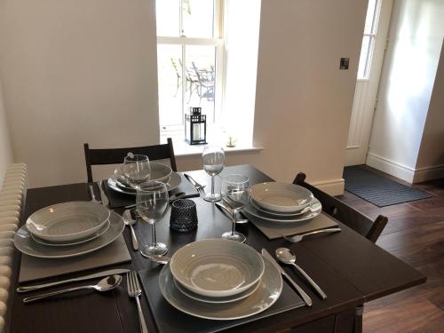una mesa de comedor con platos y copas de vino en Rectory Cottage. Close to Enniskillen and lakes., en Enniskillen