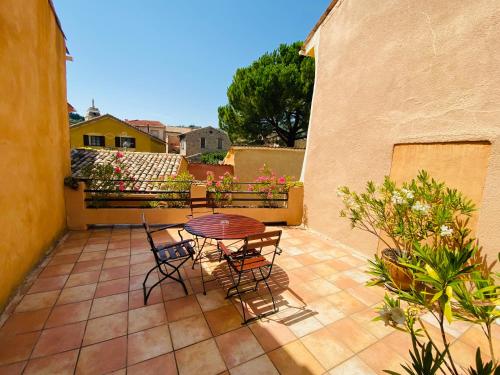 a patio with a table and chairs on a balcony at Les Arcades Le Lion D'or in Buis-les-Baronnies