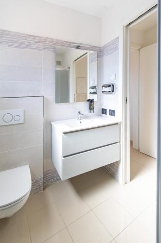 a bathroom with a white sink and a toilet at Villa Cisa in Lignano Sabbiadoro