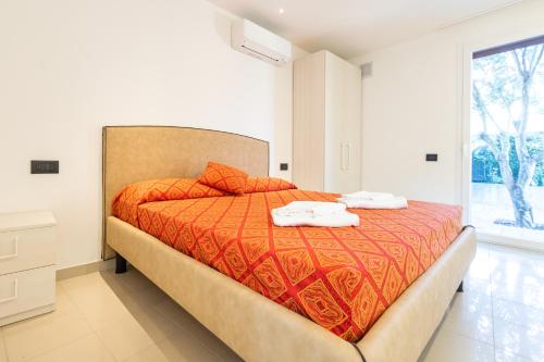 a bedroom with a bed with two towels on it at Villa Cisa in Lignano Sabbiadoro