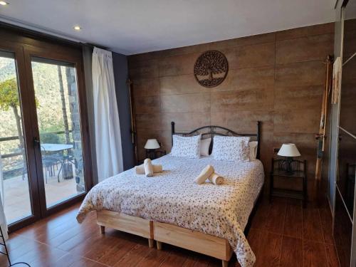 ein Schlafzimmer mit einem Bett mit einer Holzwand in der Unterkunft Casita dúplex en Casa Rural Camp de Claror in Sant Julià de Lòria