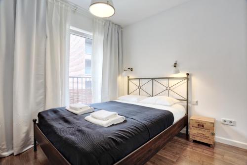 um quarto com uma cama grande e toalhas em Tyzenhauz Apartments Piwna Street em Cracóvia