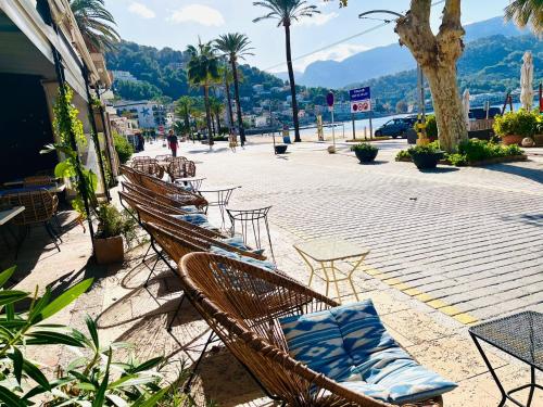 a row of chairs sitting on a street with mountains at Hotel Miramar in Port de Soller