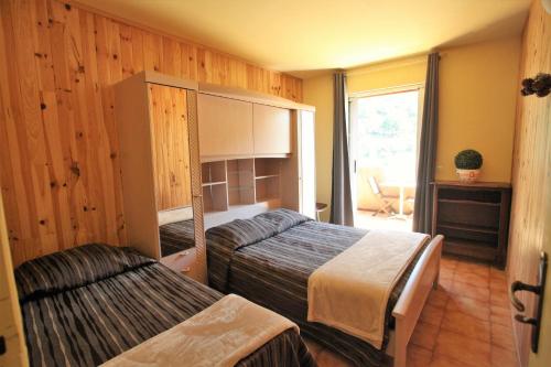 a bedroom with two beds and a window at Acropole Asco in Asco