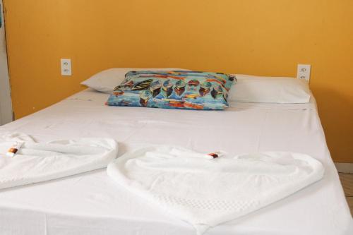 a bed with two white towels on top of it at Pousada Vila do Penedo in Penedo