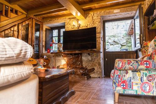 a living room with a tv and a fireplace at Casa Rural Yoruba in Amés