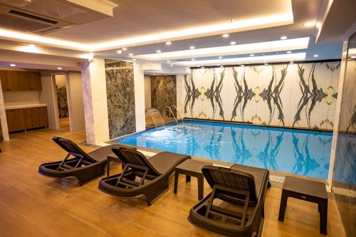 uma grande piscina com cadeiras e uma mesa num quarto em Hamitbey Hotel Yenikapı em Istambul