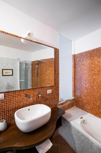 a bathroom with a large white sink and a tub at Aeneas' Landing Resort in Gaeta