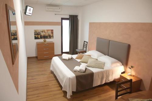 a bedroom with a large bed with two towels on it at Adams Rooms - Affittacamere in San Giovanni Lupatoto