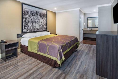 a hotel room with a bed and a bathroom at Super 8 by Wyndham North Hollywood in North Hollywood