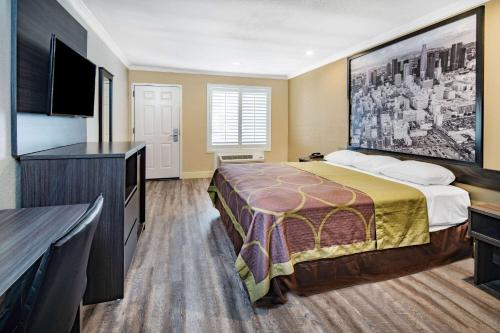 a hotel room with a bed and a flat screen tv at Super 8 by Wyndham North Hollywood in North Hollywood