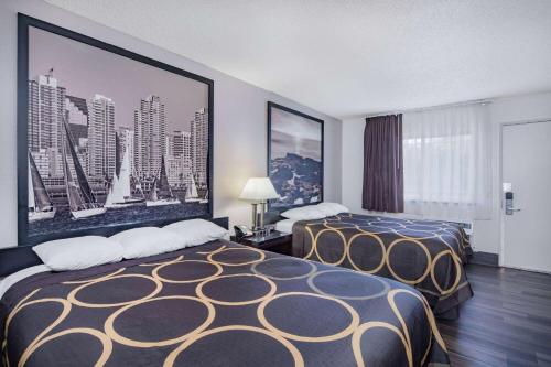 una habitación de hotel con 2 camas y un cuadro en la pared en Super 8 by Wyndham San Diego Hotel Circle en San Diego