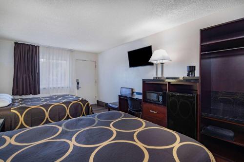 a hotel room with two beds and a flat screen tv at Super 8 by Wyndham San Diego Hotel Circle in San Diego