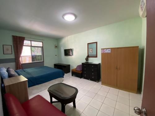 um quarto com uma cama, uma secretária e um sofá em Nan Inn Bungalow em Praia de Karon