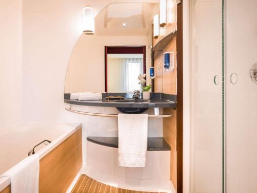 a bathroom with a sink and a mirror at Novotel Suites Cannes Centre in Cannes