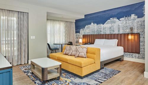 a hotel room with a bed and a couch at Hyatt Centric the Pike Long Beach in Long Beach