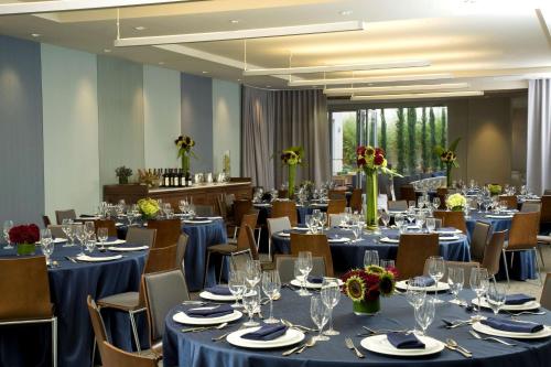 a banquet hall with blue tables and chairs with glasses at Hyatt Centric the Pike Long Beach in Long Beach
