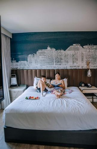 a couple of people sitting on a bed at Hyatt Centric the Pike Long Beach in Long Beach
