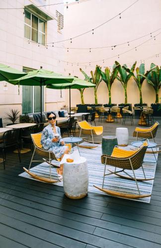 a woman sitting in a chair on a patio at Hyatt Centric the Pike Long Beach in Long Beach