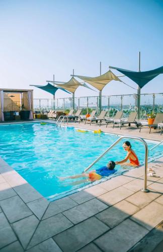 two children playing in a swimming pool on a building at Hyatt Centric the Pike Long Beach in Long Beach