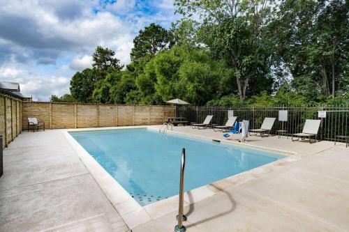 a swimming pool with chairs and a fence at La Quinta by Wyndham Chattanooga - East Ridge in Chattanooga