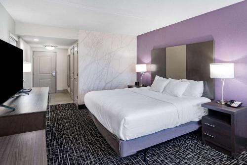 a hotel room with a large bed and a flat screen tv at La Quinta by Wyndham Chattanooga - East Ridge in Chattanooga