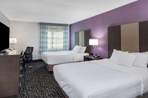a hotel room with two beds and a flat screen tv at La Quinta by Wyndham Chattanooga - East Ridge in Chattanooga
