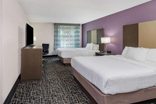 um quarto de hotel com duas camas e paredes roxas em La Quinta by Wyndham Chattanooga - East Ridge em Chattanooga