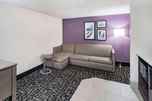 a living room with a couch and a purple wall at La Quinta by Wyndham Chattanooga - East Ridge in Chattanooga