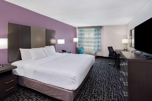a hotel room with a large bed and a flat screen tv at La Quinta by Wyndham Chattanooga - East Ridge in Chattanooga