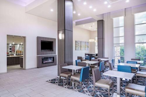 a restaurant with tables and chairs and a fireplace at La Quinta by Wyndham Chattanooga - East Ridge in Chattanooga