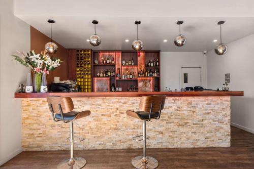 a bar with two chairs in front of a brick wall at Comfort Inn Moree in Moree