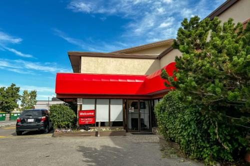 a car parked in front of a store with a red awning at Econo Lodge Motel Village in Calgary