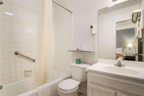 a white bathroom with a toilet and a sink at Econo Lodge Bartlesville Hwy 75 in Bartlesville