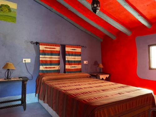 プリエゴ・デ・コルドバにあるPosada Niña Margaritaの赤い部屋のベッド1台が備わるベッドルーム1室